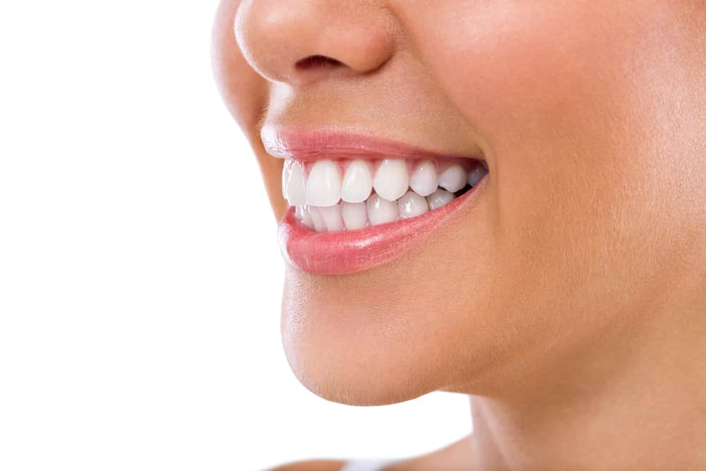 A close-up of a smiling person with bright, white teeth.